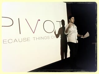 A man standing in front of a screen with the word pivot.