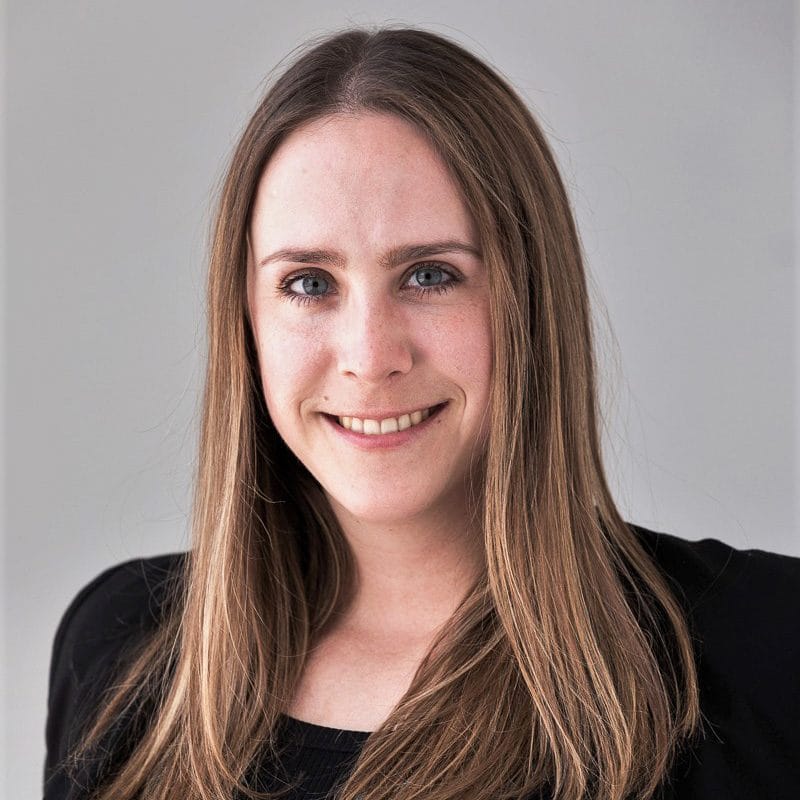 A woman with long hair smiling for the camera.