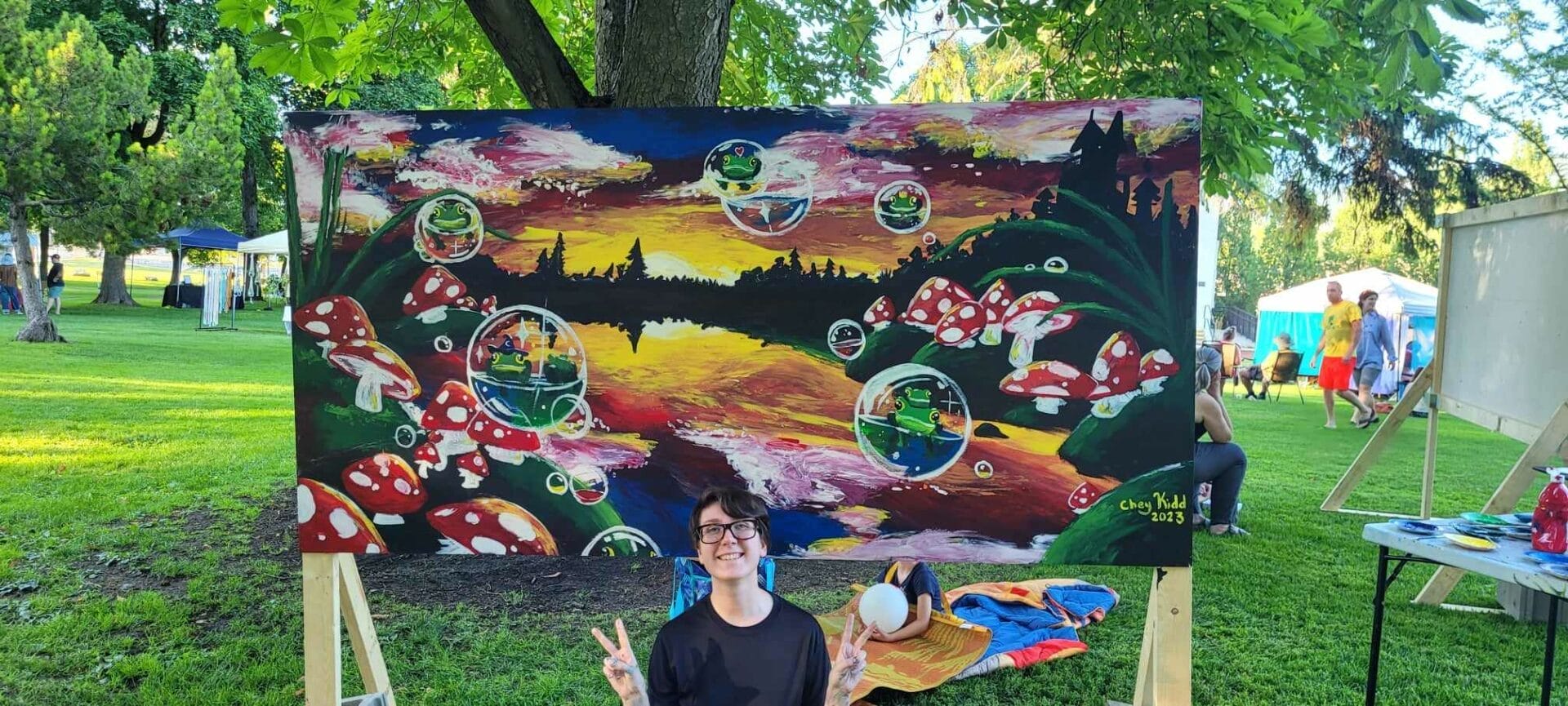 Centre grad Chey Kidd posing in front of their winning painting from a recent art battle event in Vernon.  