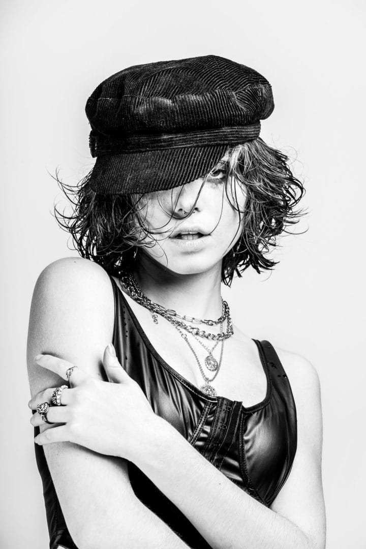 A black and white photo of a woman wearing a hat.