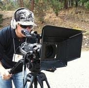 A man with a camera on a tripod.