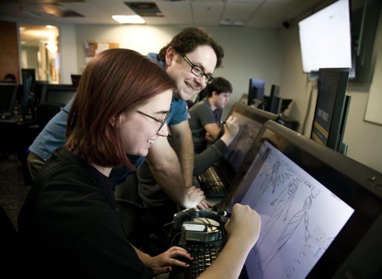 A 2D Animation & Digital Art student showing her instructor the project she's working on, both smiling at the screen. This snapshot captures the collaborative spirit and creative exchange fostered within the Centre for Arts and Design's dynamic learning environment.