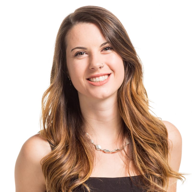 A woman with long brown hair and a nose ring smiles while wearing a black top and a necklace. Alumni Cassidy Stober, from the Centre for Arts and Technology, epitomizes creativity and style effortlessly.