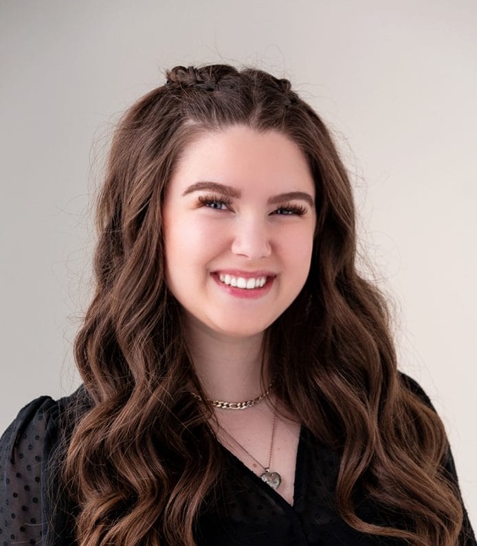 A young woman smiling in a black top.