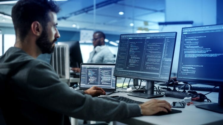 A man is working on a computer in an office.