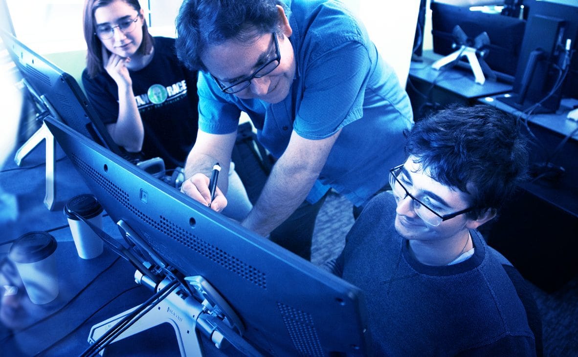 A group of people looking at a computer screen.