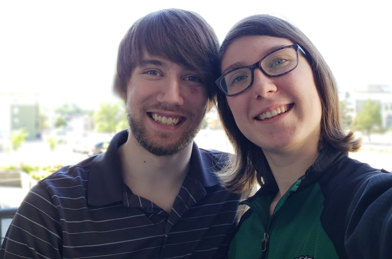 A man and woman taking a selfie in front of a building.