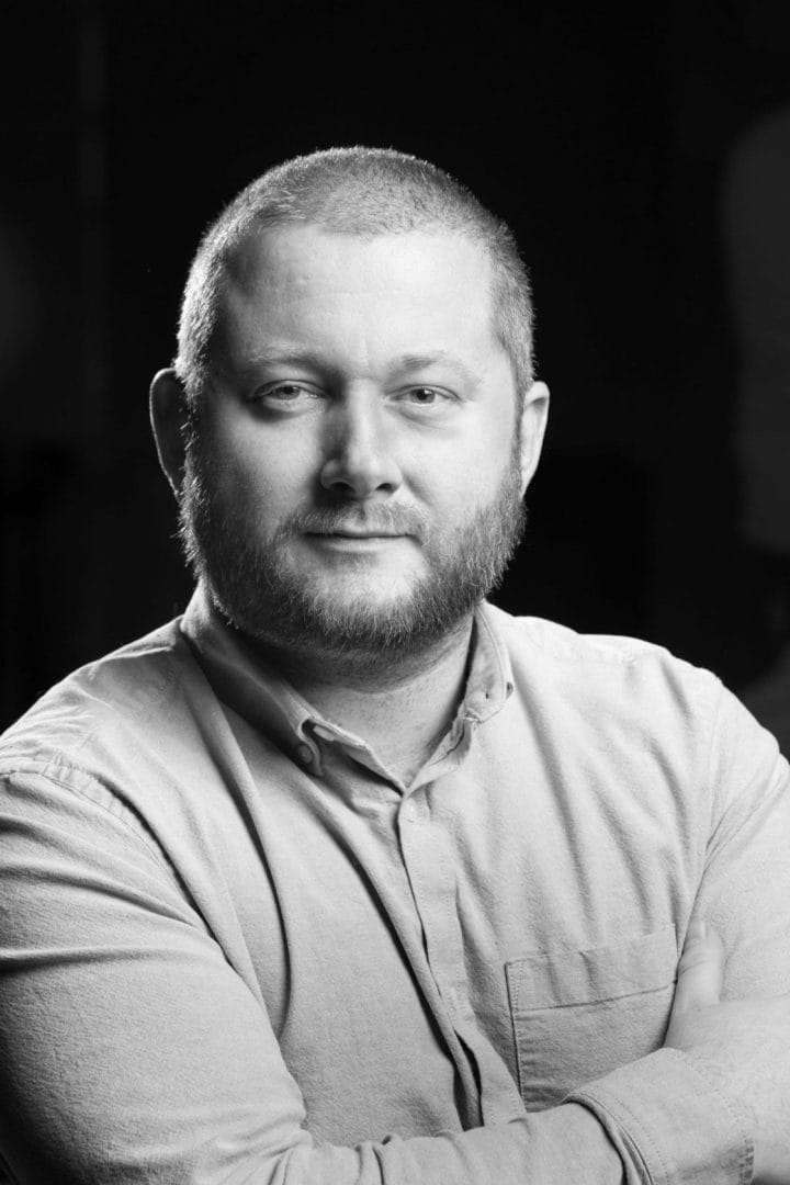 A black and white photo of a man with a beard.