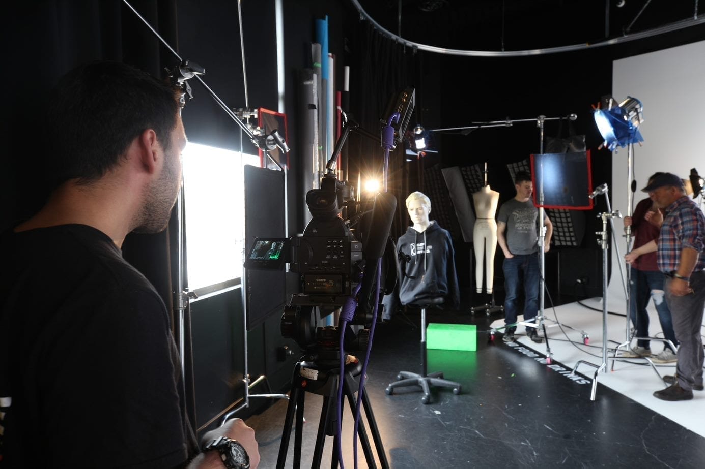 A group of people filming in a studio.