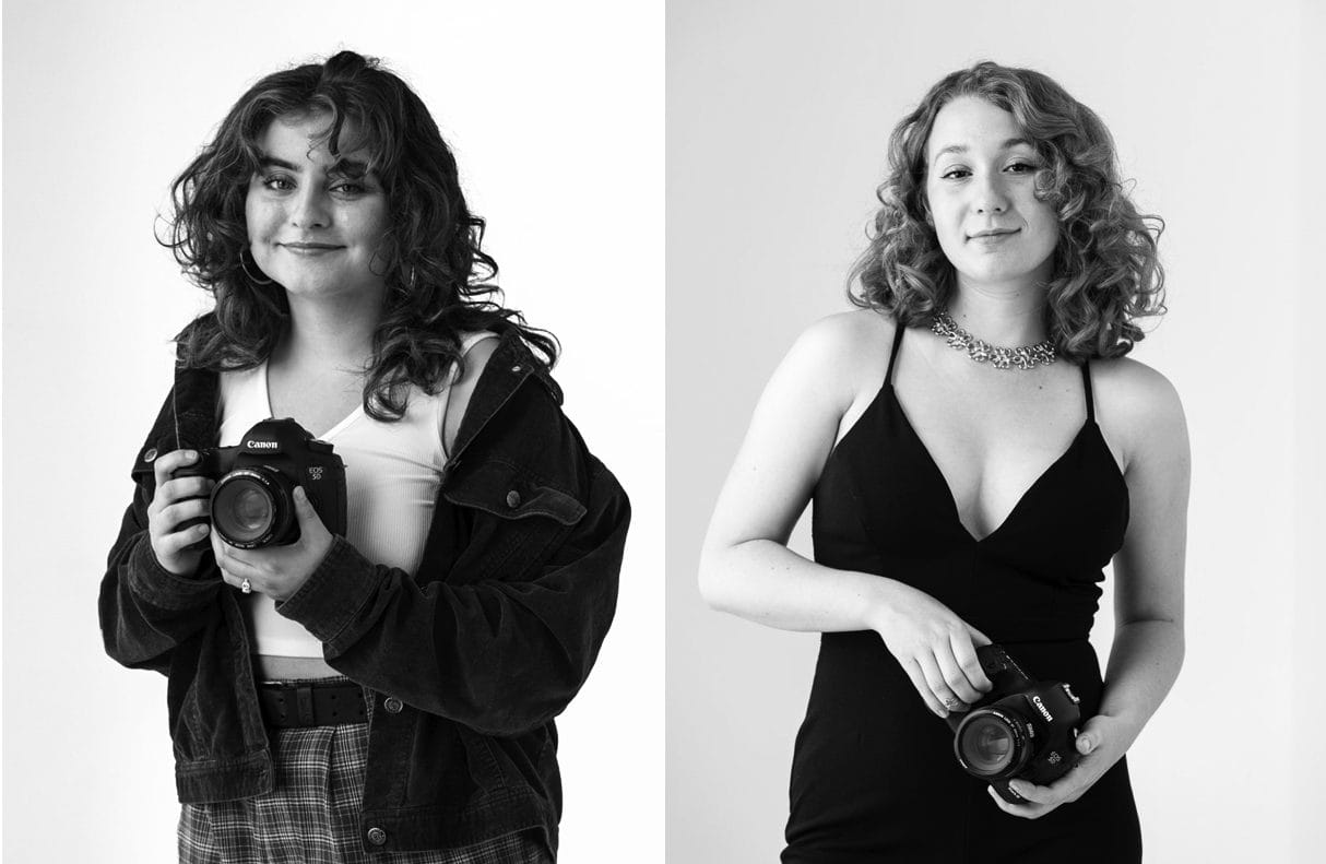 A black and white photo of a woman holding a camera.