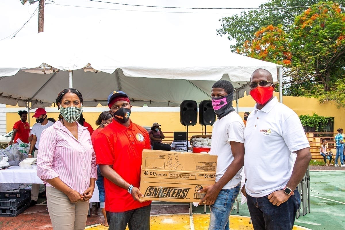 A group of people with masks posing in front of a box.