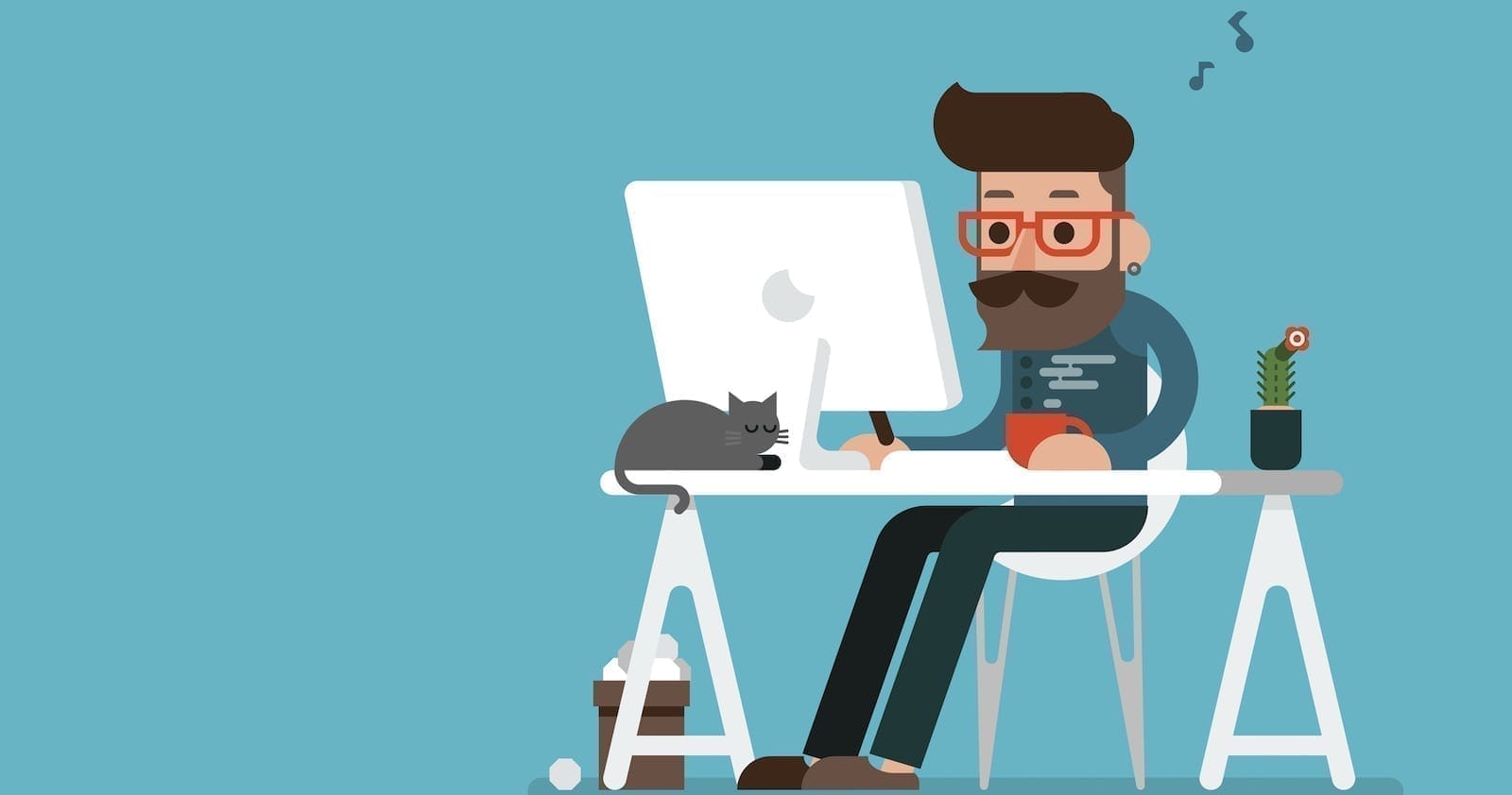 A man sitting at a desk with a cat on his lap.