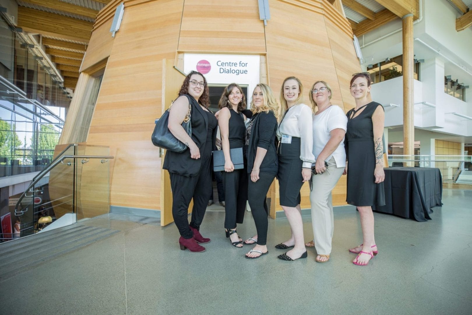 A group of women posing in front of a building.