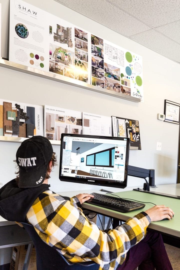 A man sits at a desk with a computer in front of him.