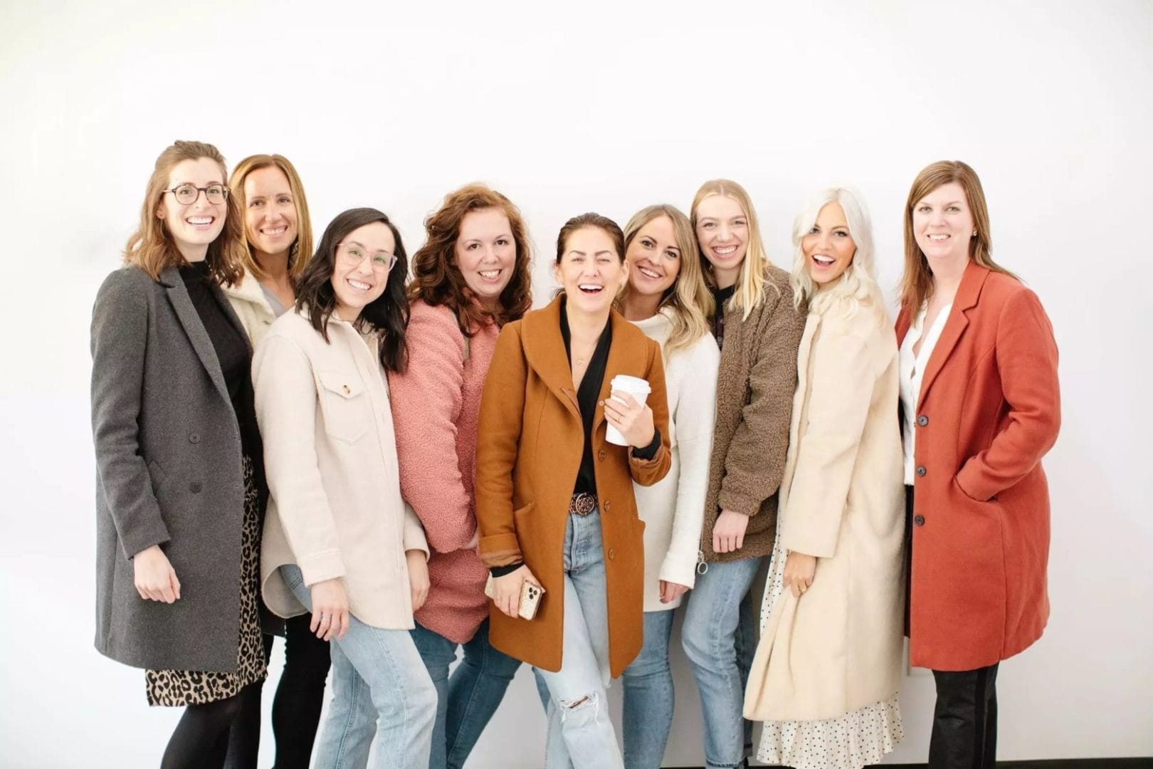 A group of women in coats posing for a photo.