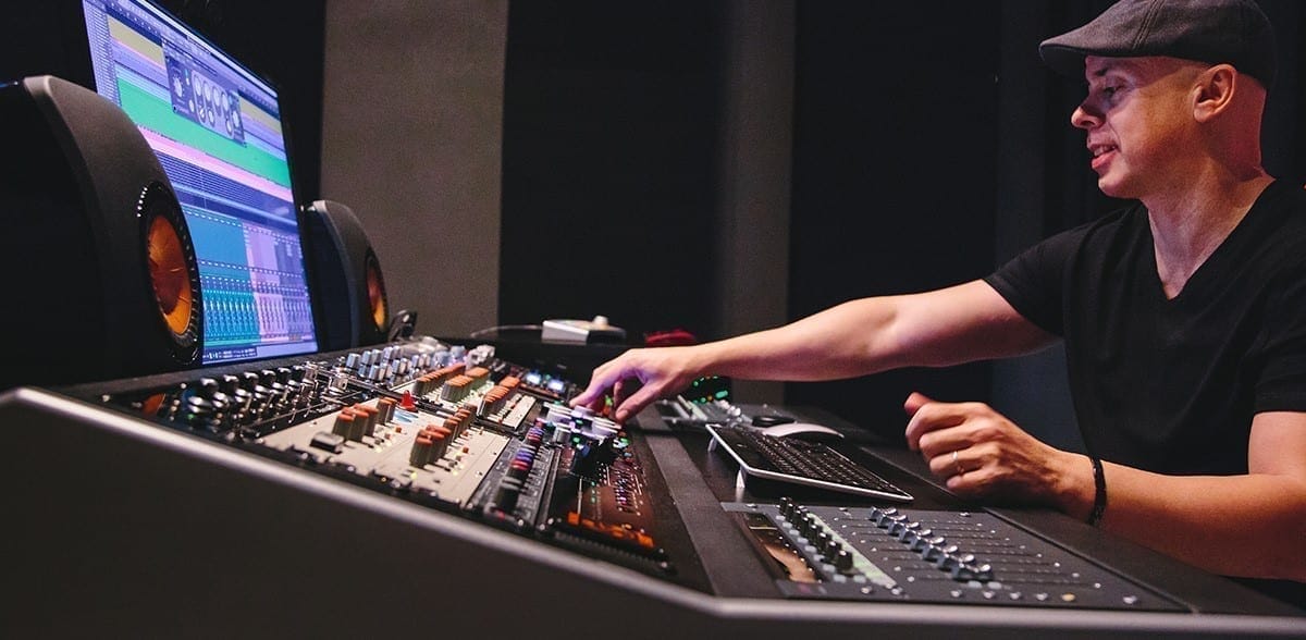 A man sitting in front of a mixing desk.