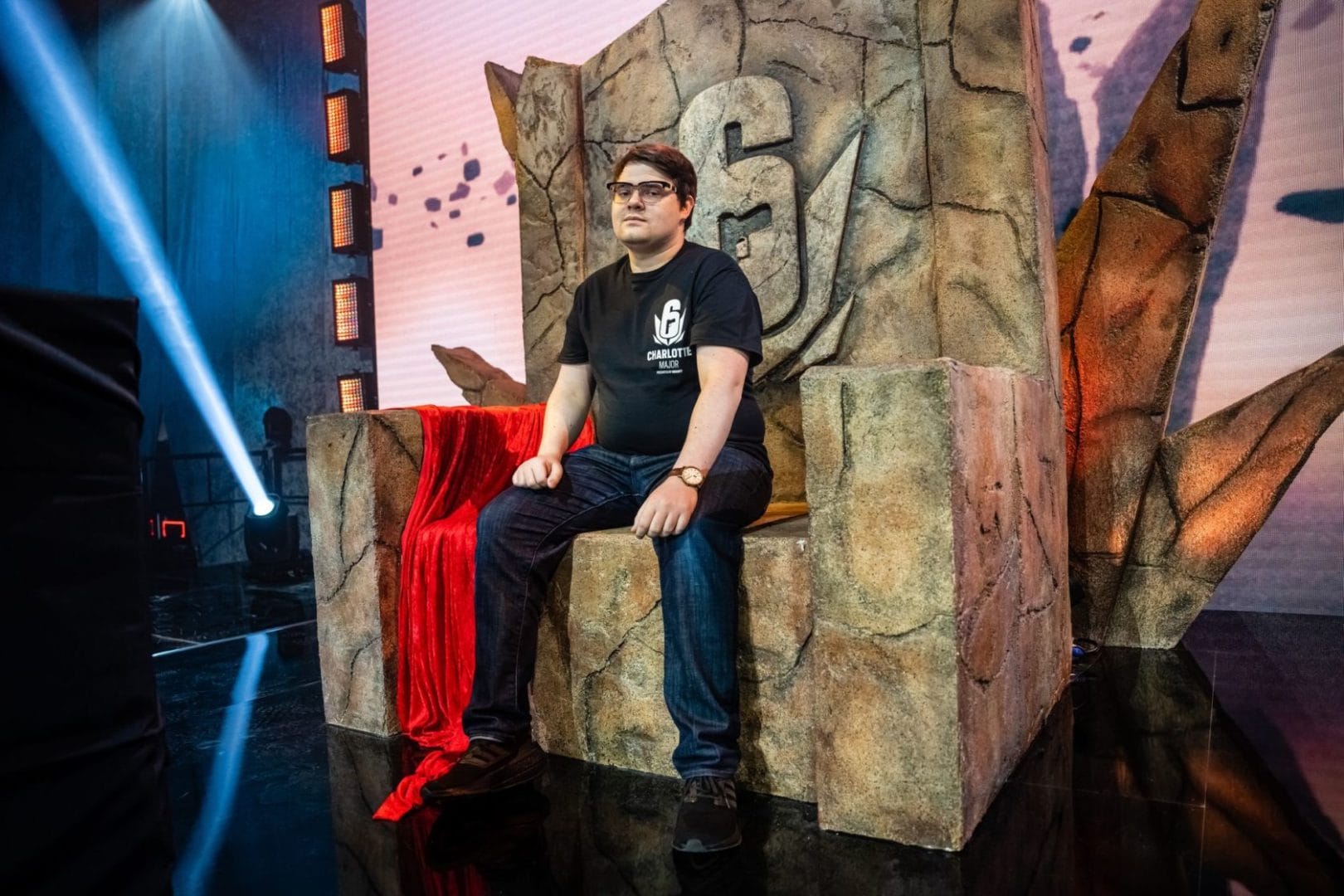 A man sitting on a throne in front of a stage.