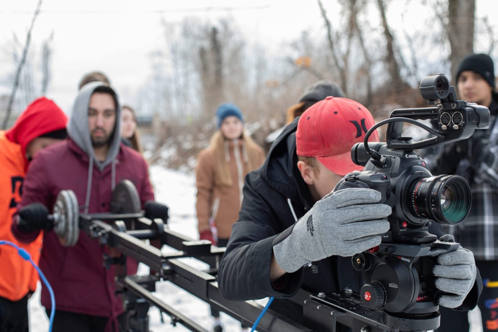 A group of people working on a camera in the snow.