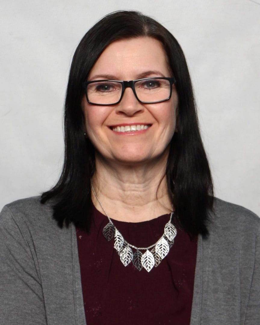 A woman wearing glasses and a necklace.