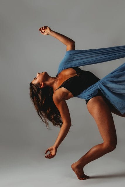 A woman in a blue dress performing a dance.