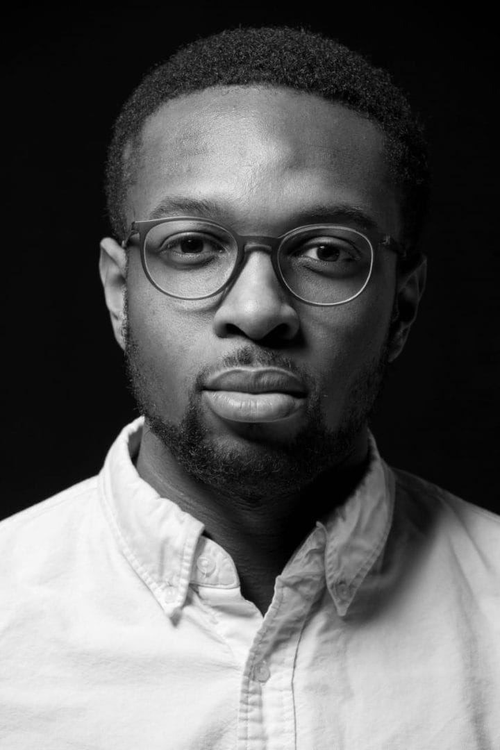 A black and white photo of a man with glasses.