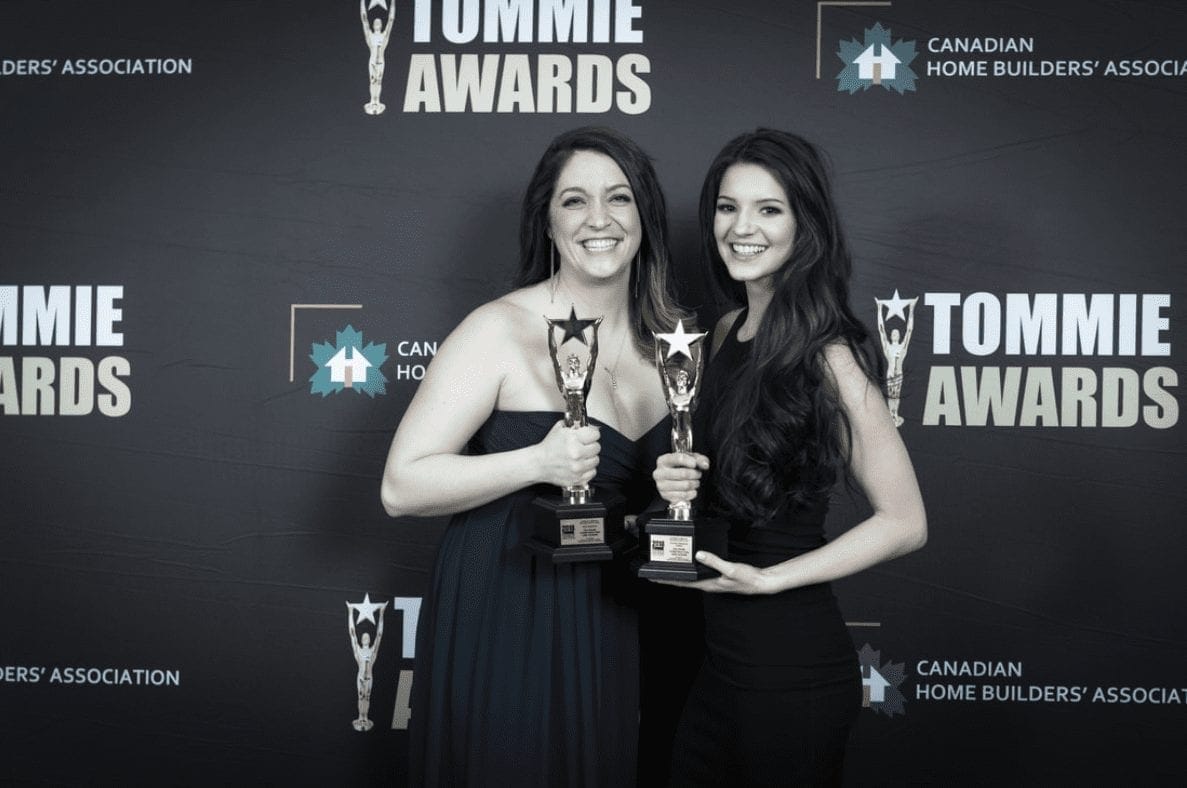 Two women posing with their trophies at the tommie awards.