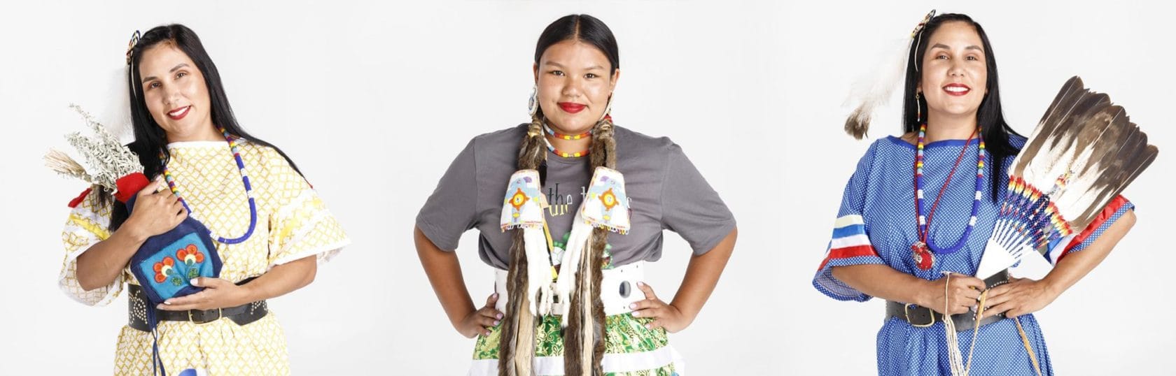 Three native american women dressed in traditional clothing.