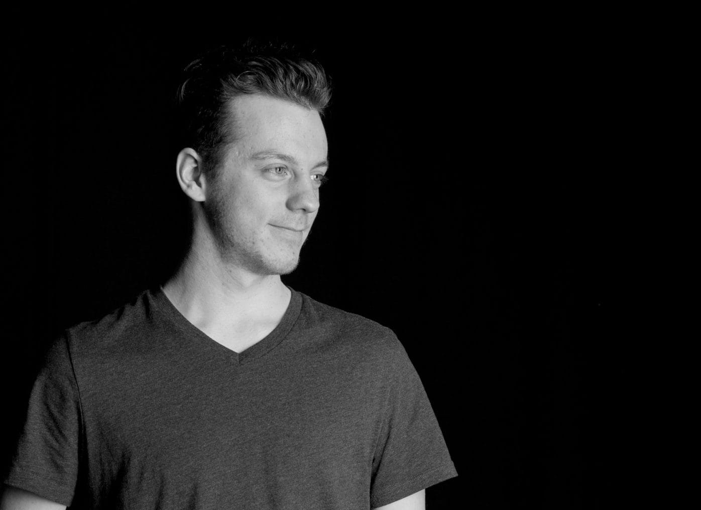 A black and white photo of a man in a v - neck shirt.